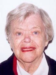 Portrait of an elderly woman with short gray hair, red lipstick, and a dark jacket over a white collar.