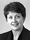 Black-and-white portrait of a smiling woman with short dark hair against a plain background