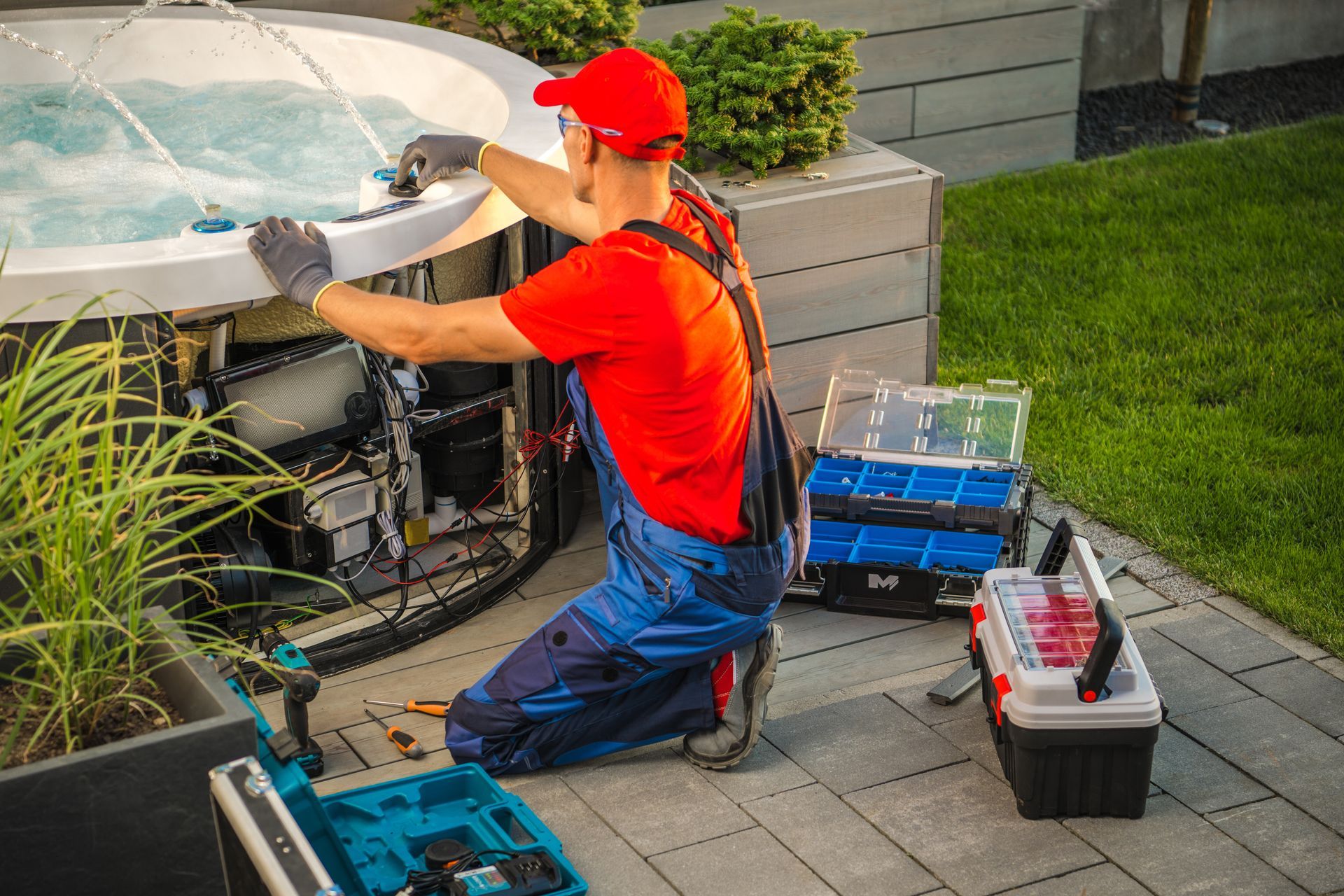 A man is working on a hot tub on a patio.