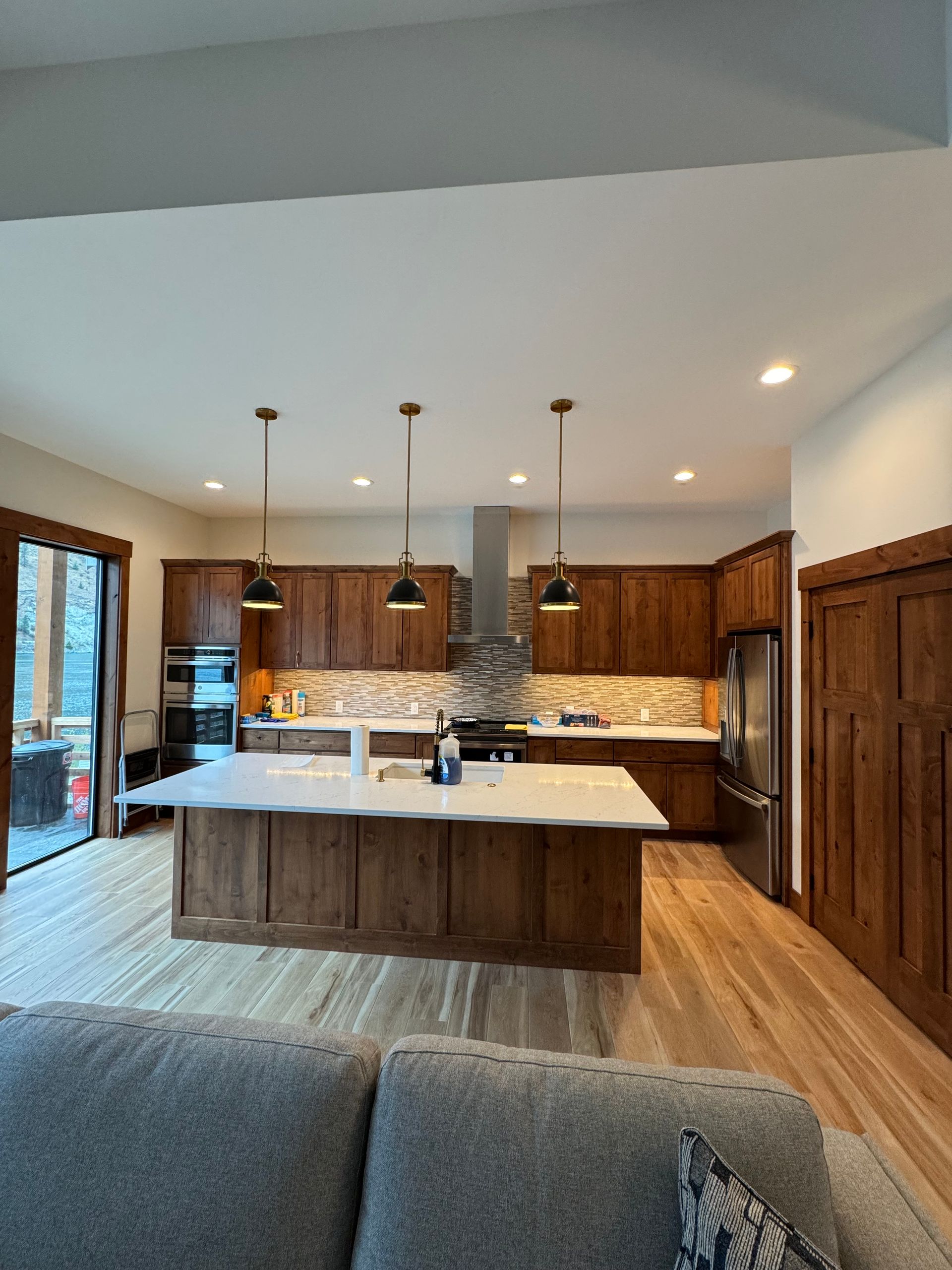 Modern kitchen with wood cabinets, large island, pendant lights, and hardwood floors