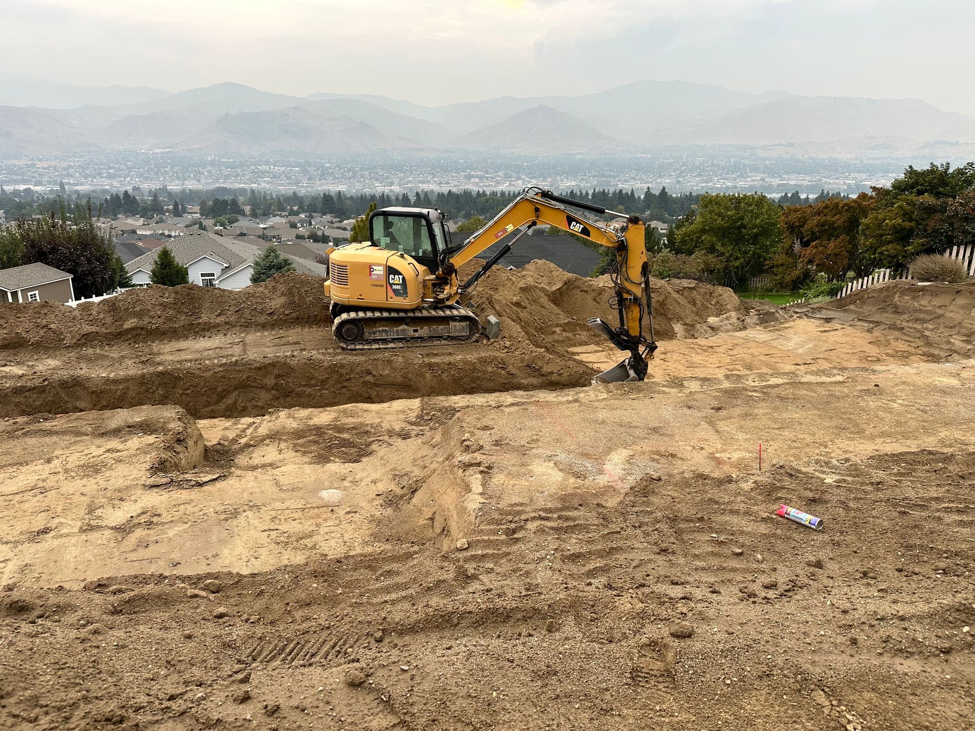 Construction site with forms and rebar for a concrete structure, within a deep excavation.