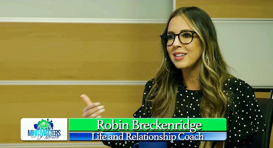 Woman speaking in glasses at a news desk, with a lower-third reading “Robin Breckenridge, Brand Relationship Coach.”