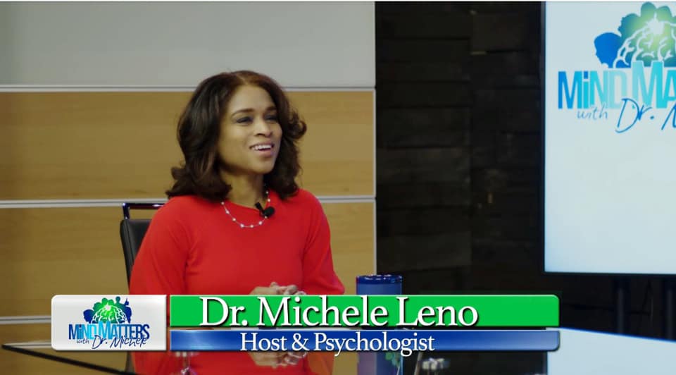 Dr. Michele Leno speaking in a studio with a “Mind Your Business” screen behind her.