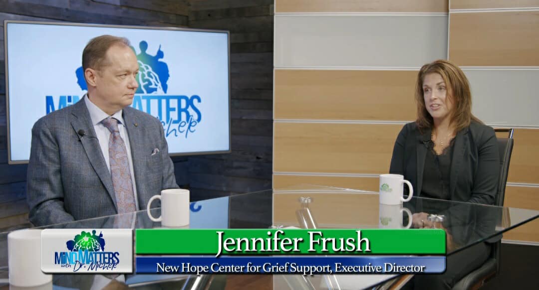 Two people seated in a TV studio interview set with a lower-third reading “Jennifer Frush.”