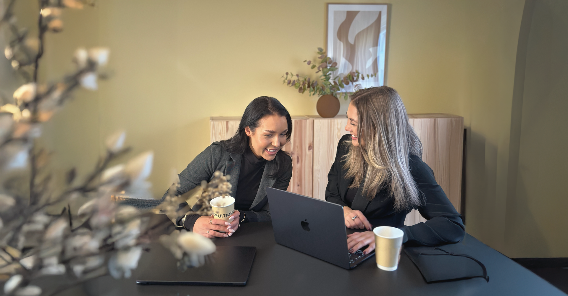 Johanna Larsson och Saga Sofiadotter skrattar vid ett bord