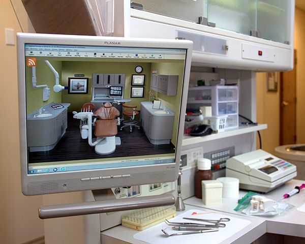 A computer monitor shows a picture of a dental office