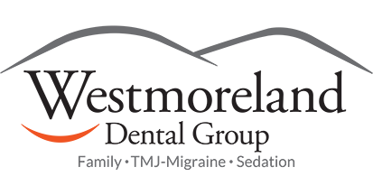 The westmoreland dental group logo is a smiling face with mountains in the background.