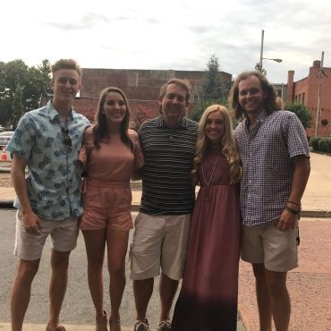 A group of people posing for a picture on a sidewalk