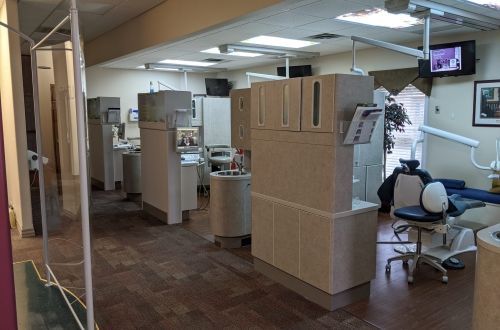 A dental office with a lot of cabinets and chairs