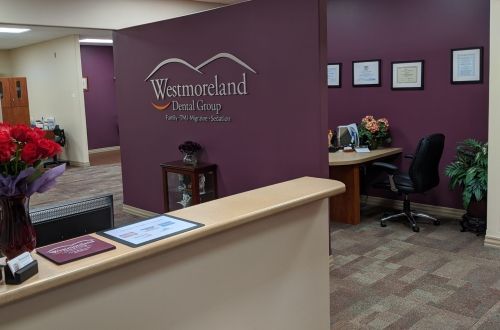 A dental office with a purple wall and a reception desk.