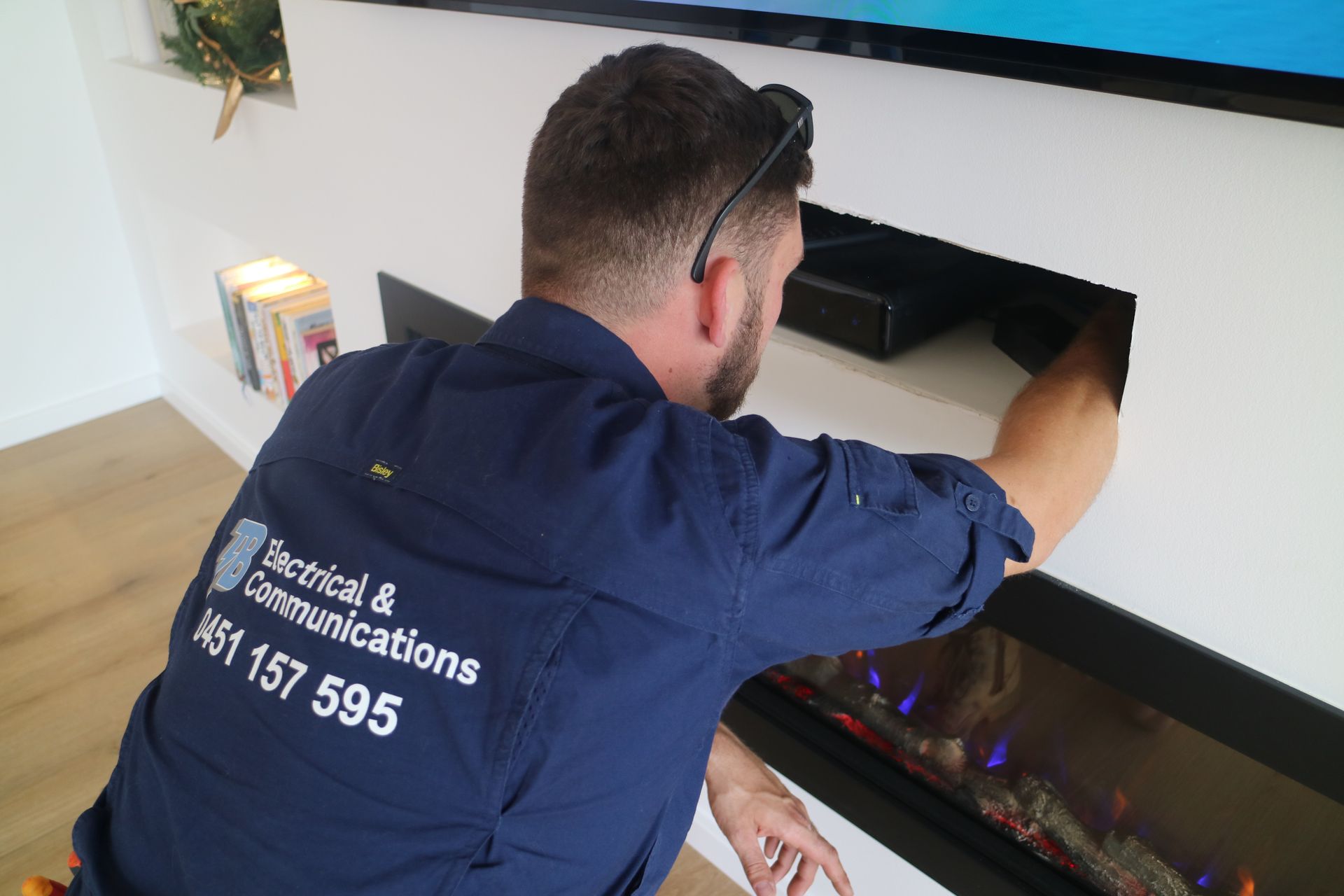 An Electrician Repairing An Appliance — TB Electrical & Communications in West Gosford, NSW