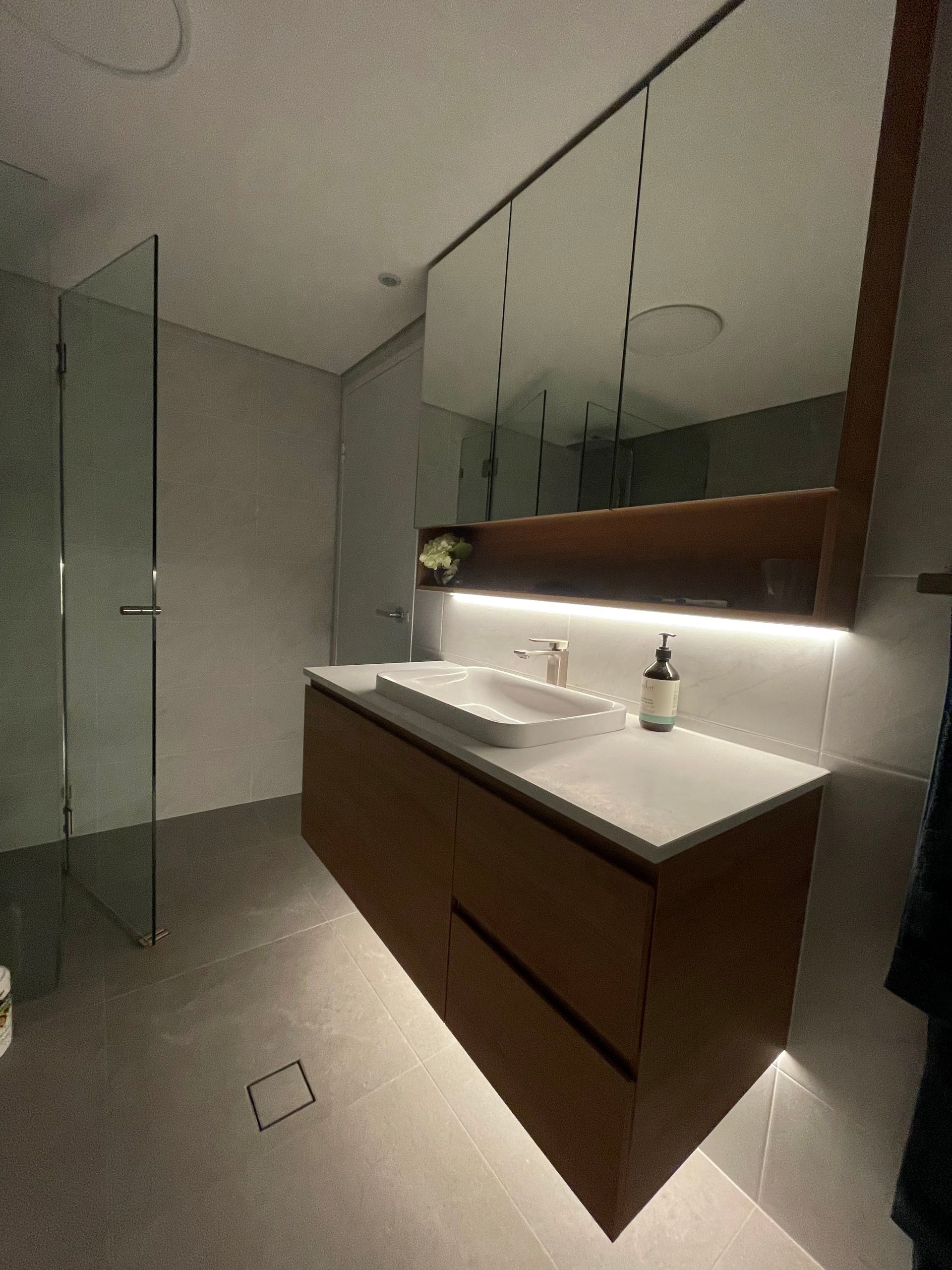A Bathroom With LEDs Under The Mirror And Basin Cabinet — TB Electrical & Communications in West Gosford, NSW
