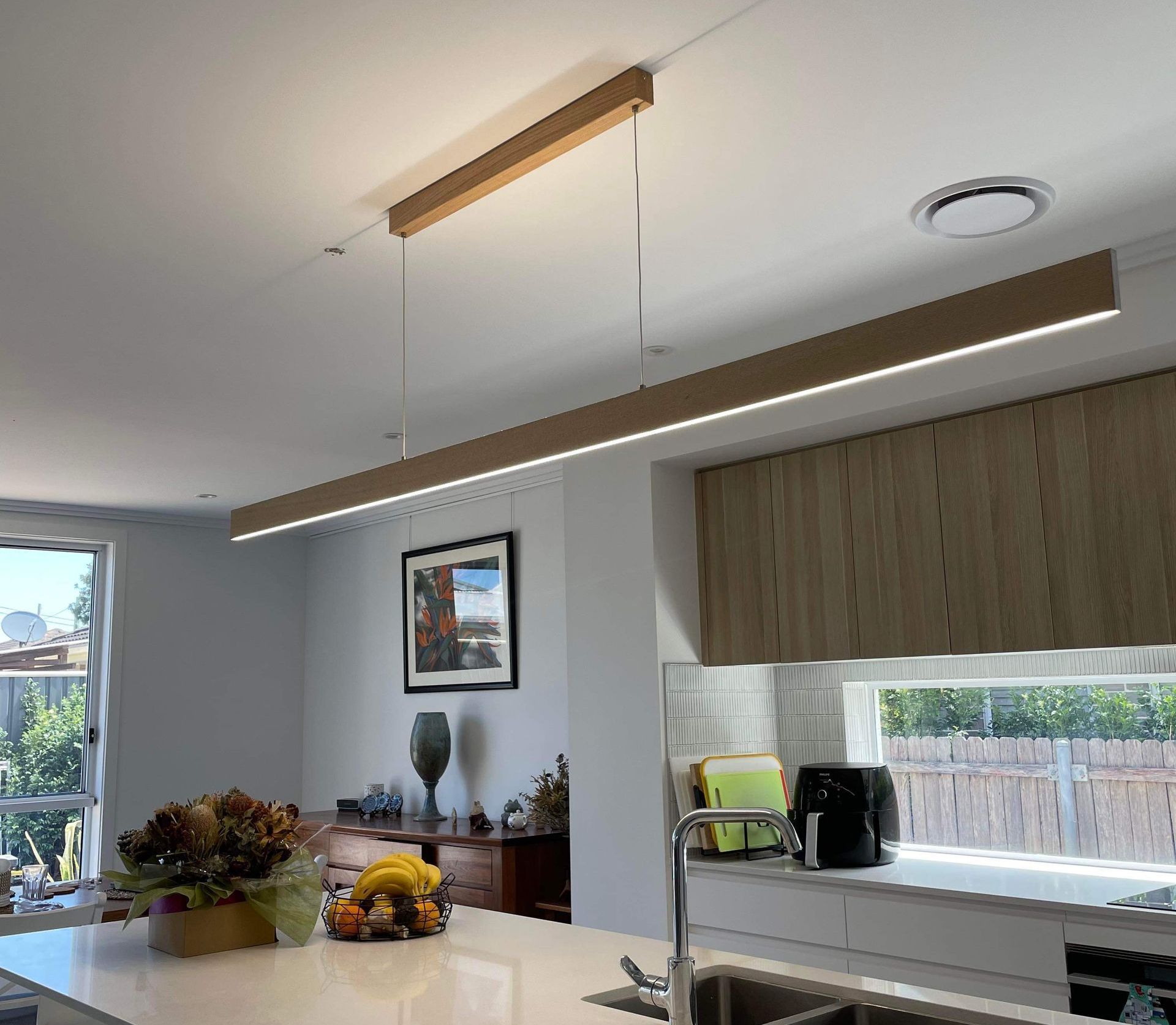 A Kitchen With A Long Light Fixture Over The Island — TB Electrical & Communications in West Gosford, NSW