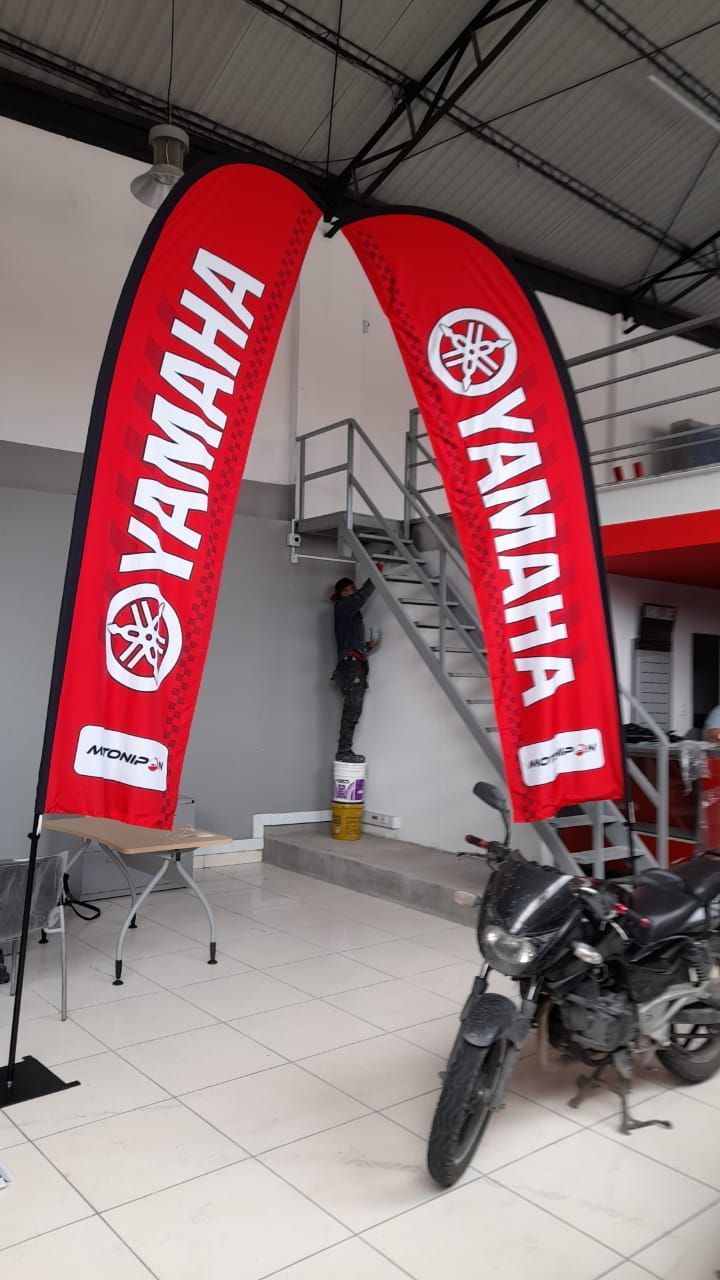 Dos banderas rojas de Yamaha cuelgan del techo sobre una motocicleta.