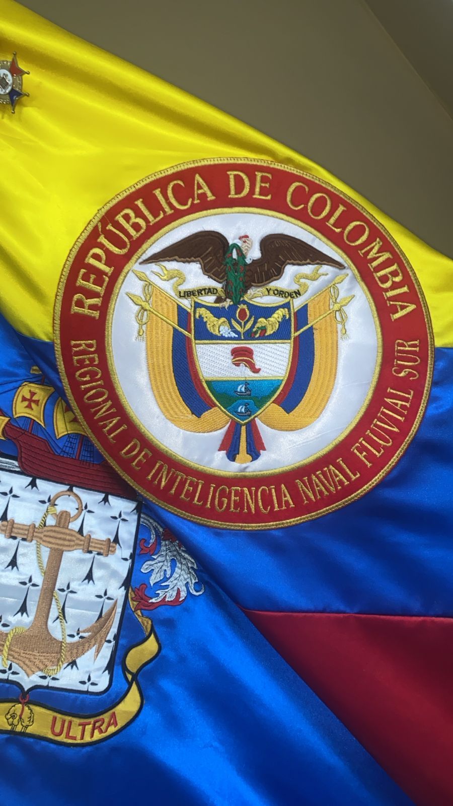 El escudo de armas de la República de Colombia está en una bandera.
