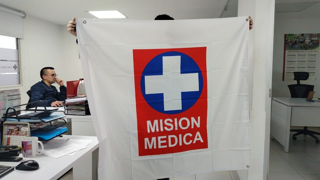 Un hombre sostiene una bandera que dice misión médica