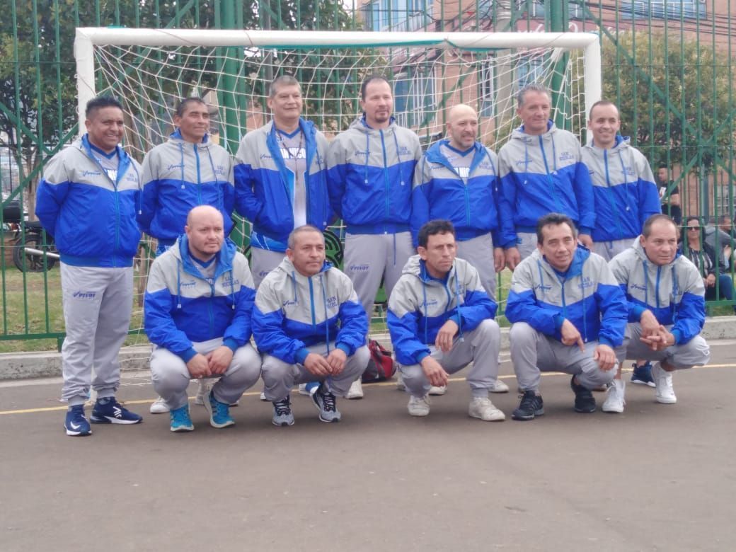 Un grupo de hombres posa para una foto frente a una portería de fútbol.