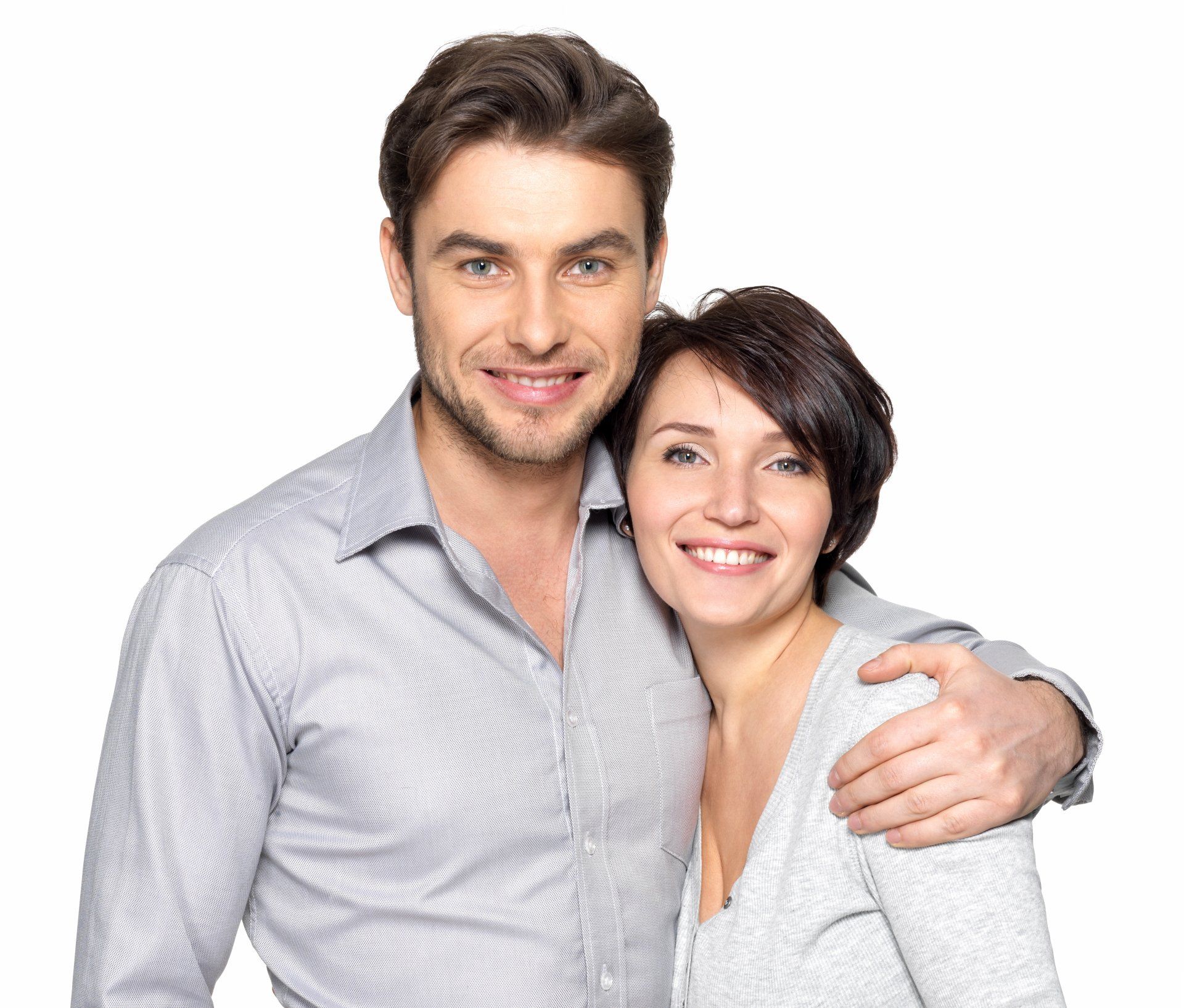 Un homme entoure une femme souriante de son bras. Ils regardent la caméra.