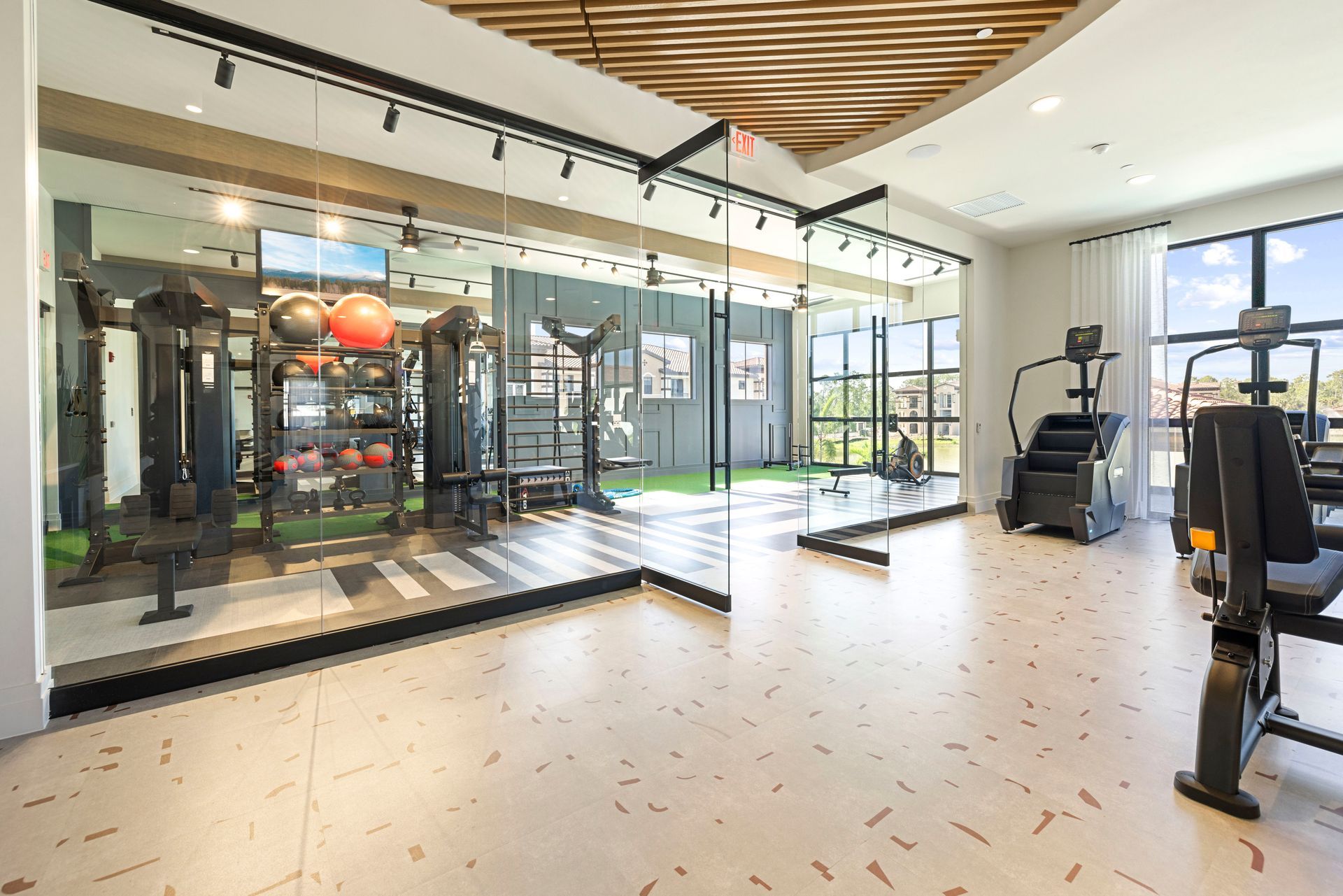 A large gym with a lot of equipment and a large mirror at Corsa at Estero Crossing.