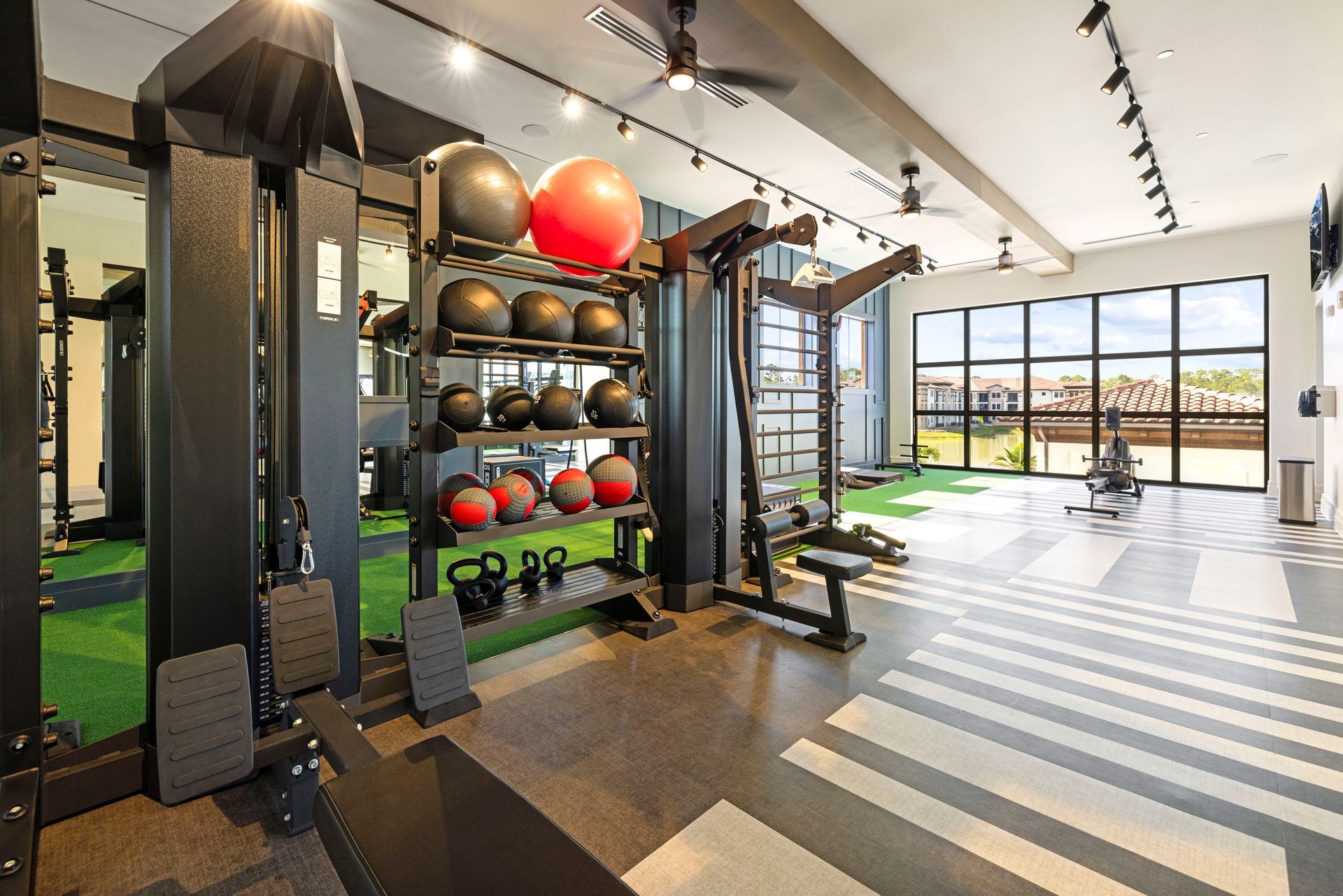 A gym with a lot of equipment and a lot of windows at Corsa at Estero Crossing.