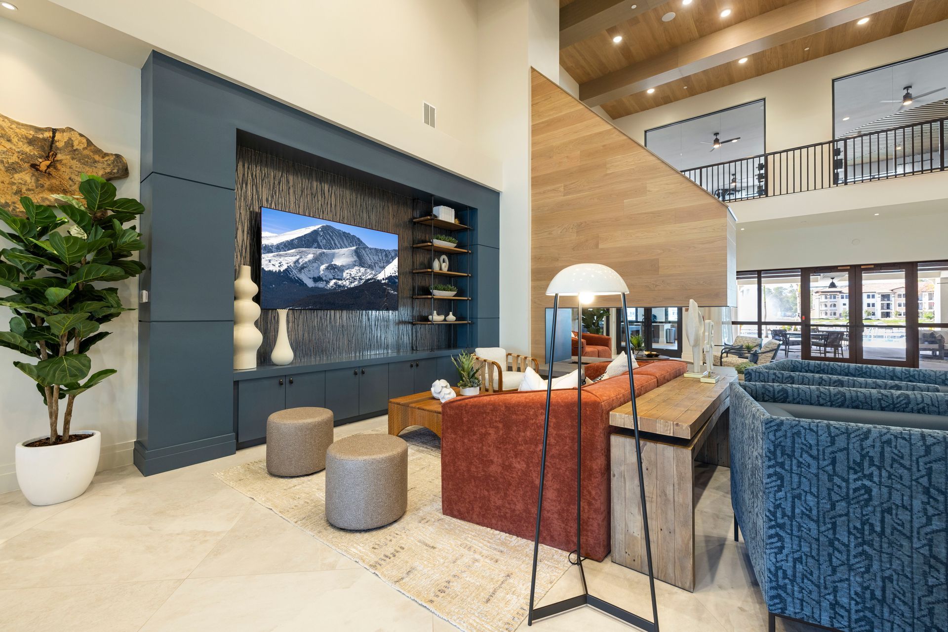A living room with a large flat screen tv on the wall at Corsa at Estero Crossing.