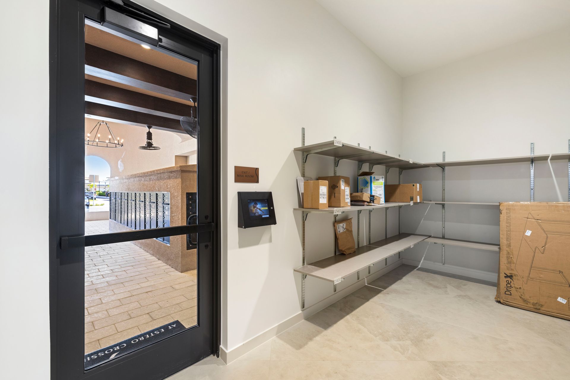 A room with a door and shelves filled with boxes at Corsa at Estero Crossing.