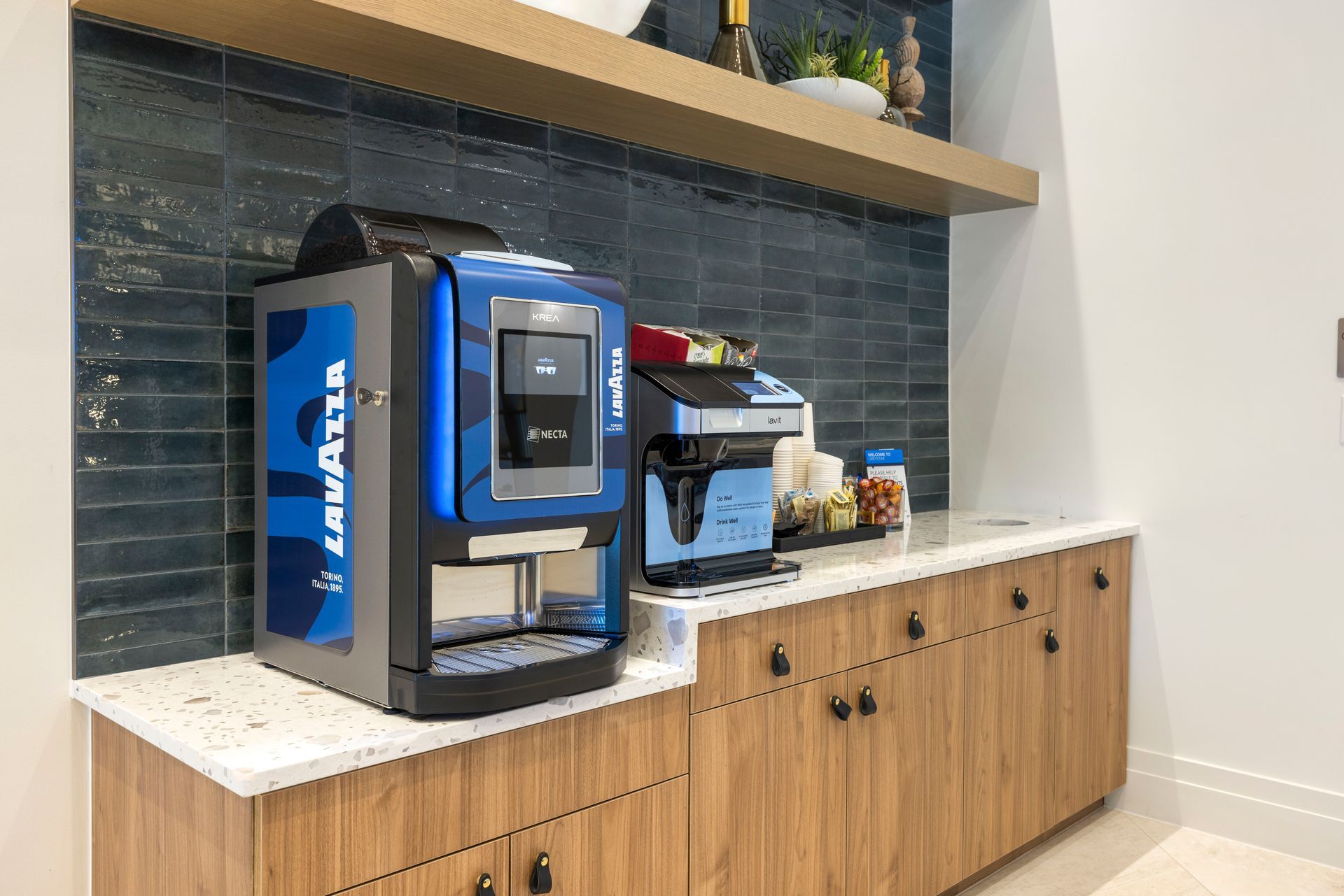 A blue lavazza coffee machine is sitting on a counter in a kitchen at Corsa at Estero Crossing.