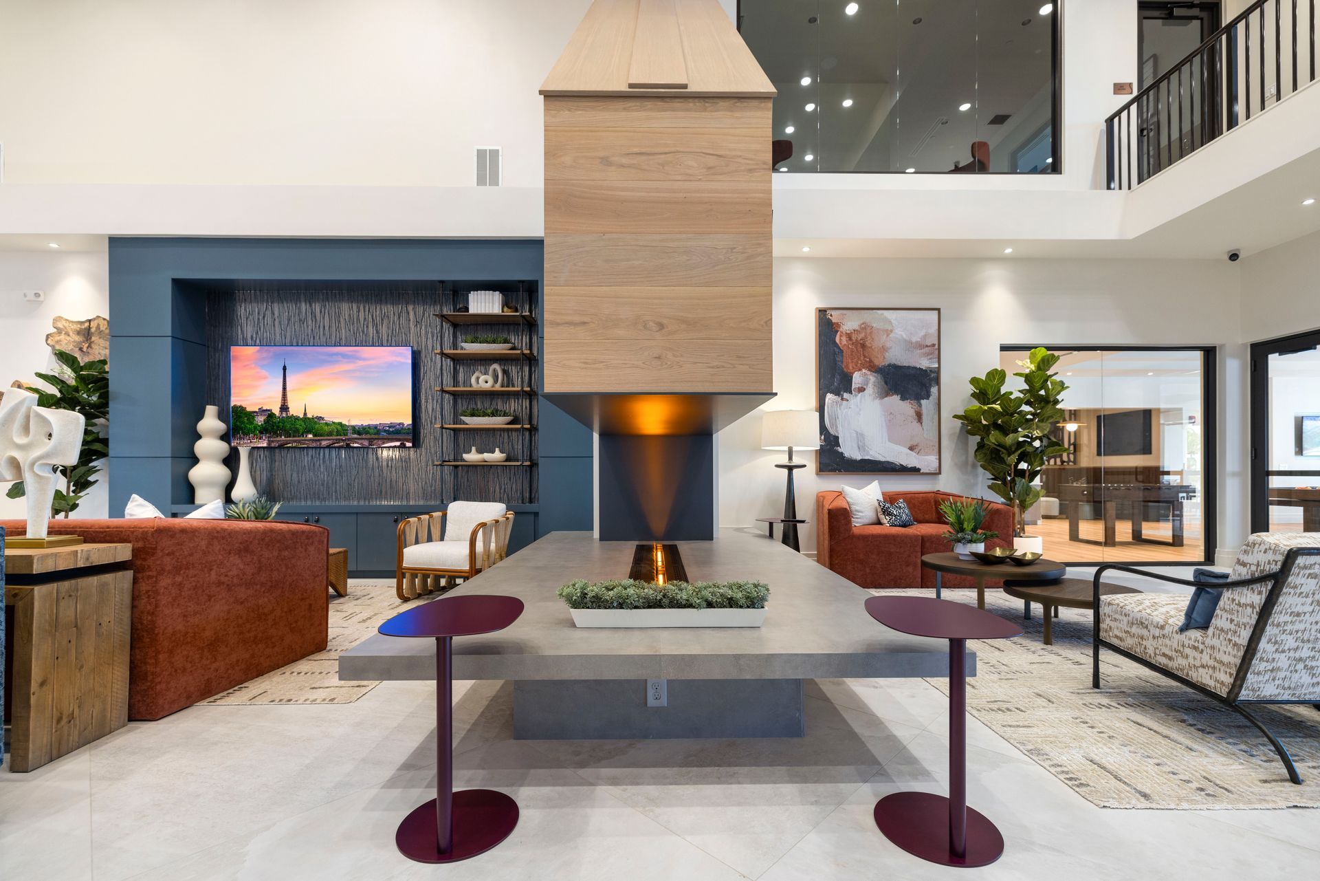 A living room with a fireplace , tables , chairs and a television at Corsa at Estero Crossing.