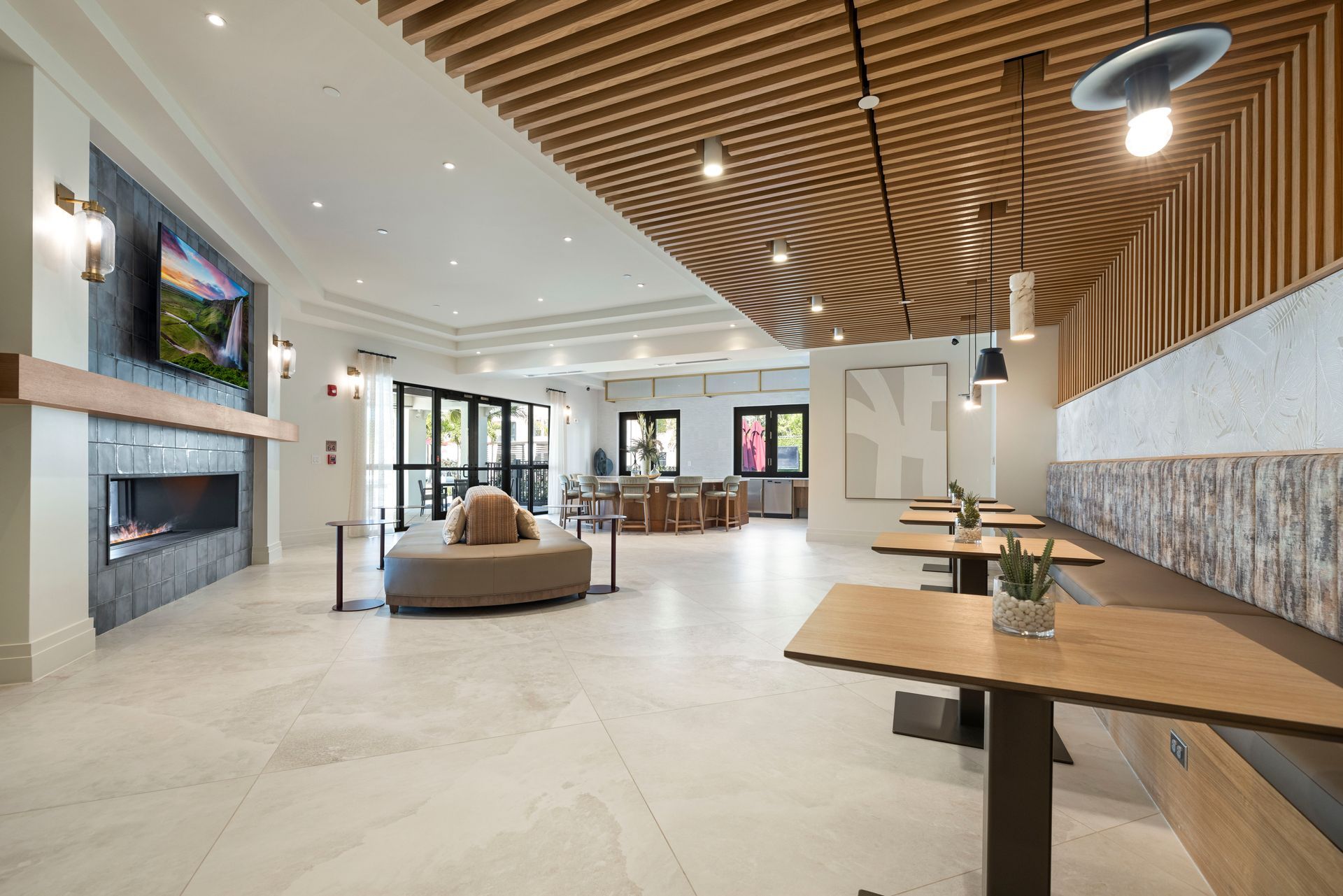 A large room with tables and a fireplace in it at Corsa at Estero Crossing.