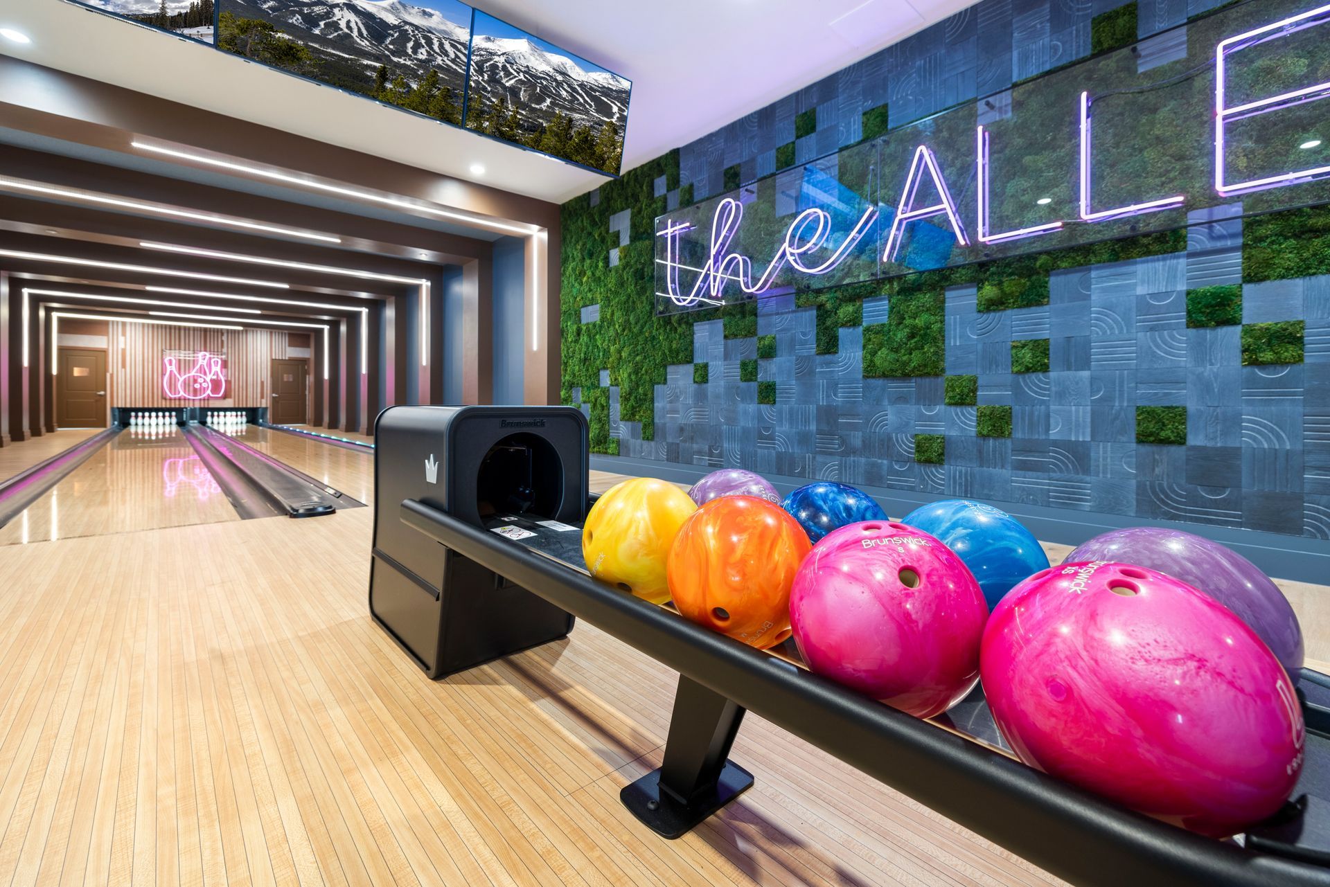 A bowling alley with a bunch of bowling balls on a rack at Corsa at Estero Crossing.