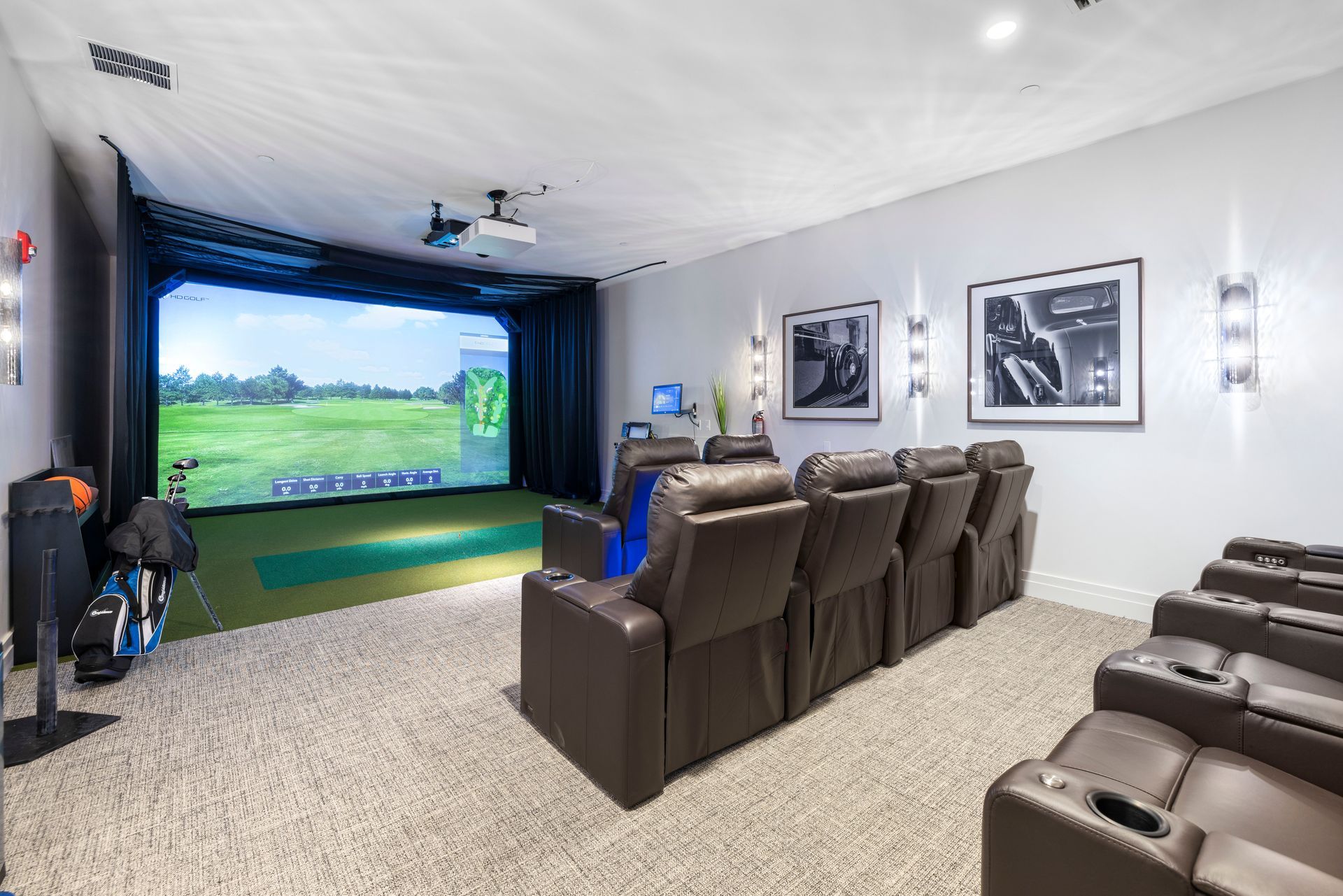 A home theater with a golf simulator in the background at Corsa at Estero Crossing.