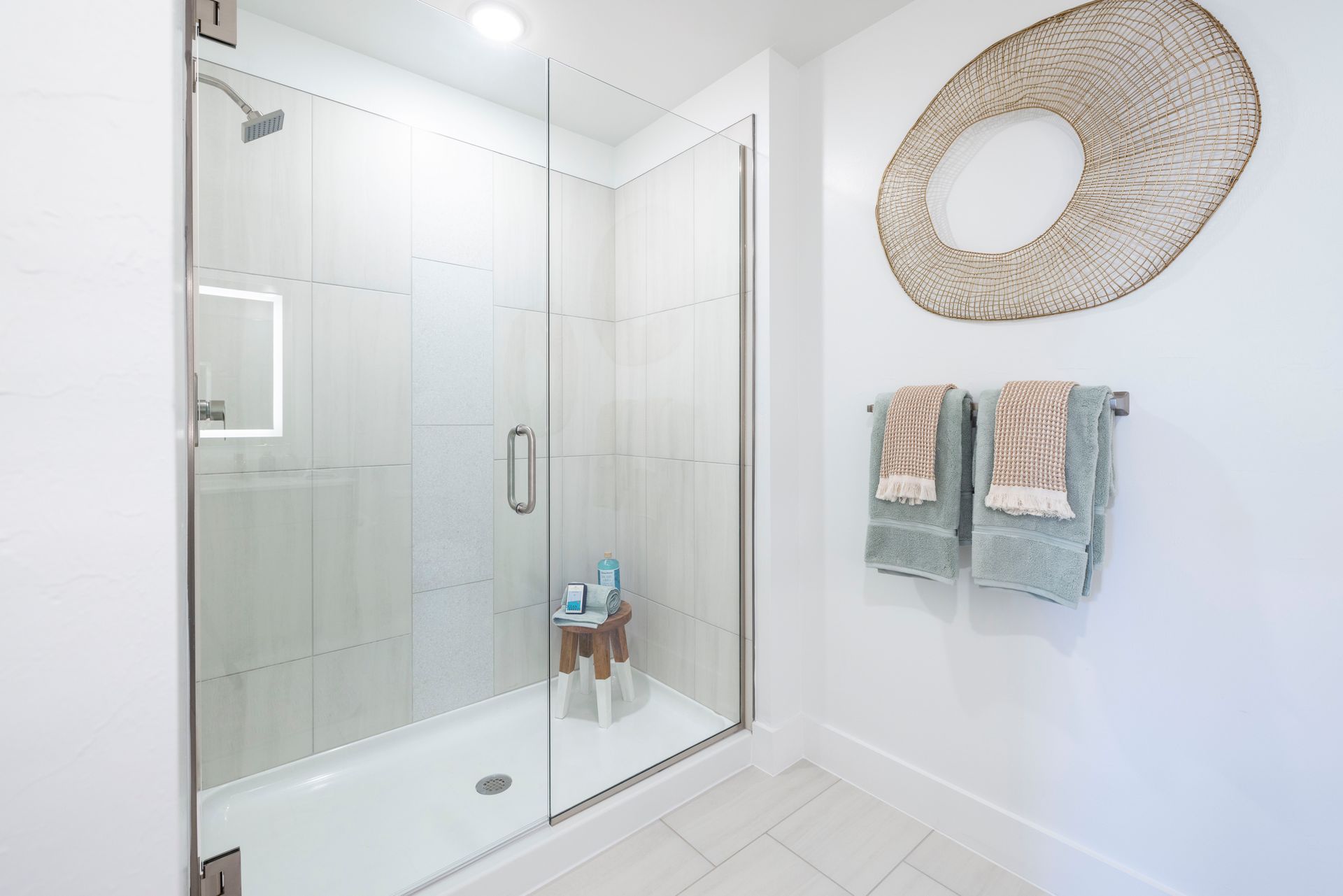 A bathroom with a walk in shower and two towels hanging on the wall at Corsa at Estero Crossing.