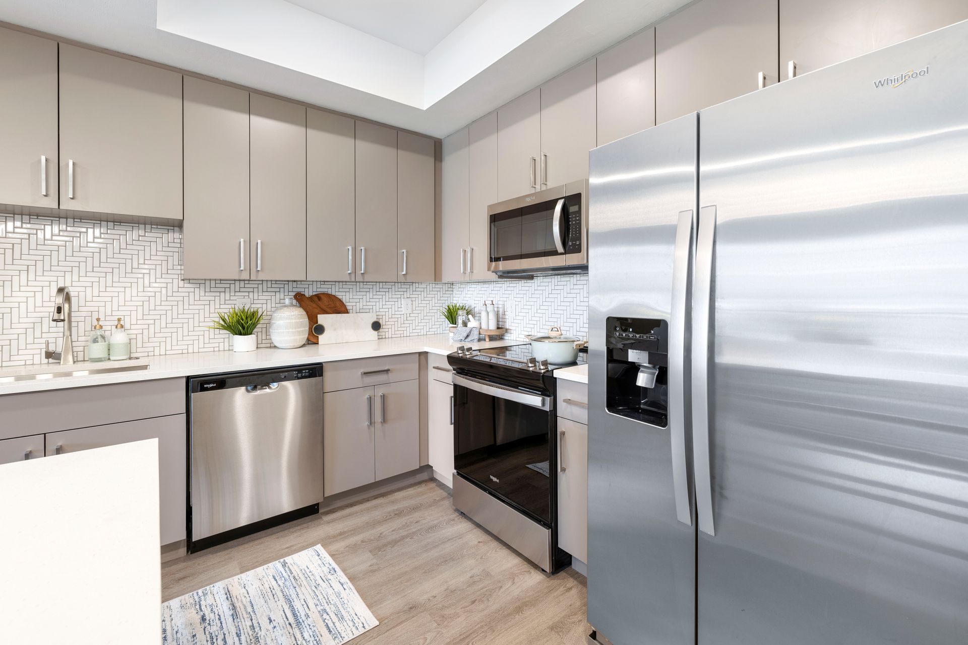 A kitchen with stainless steel appliances and a stainless steel refrigerator at Corsa at Estero Crossing.