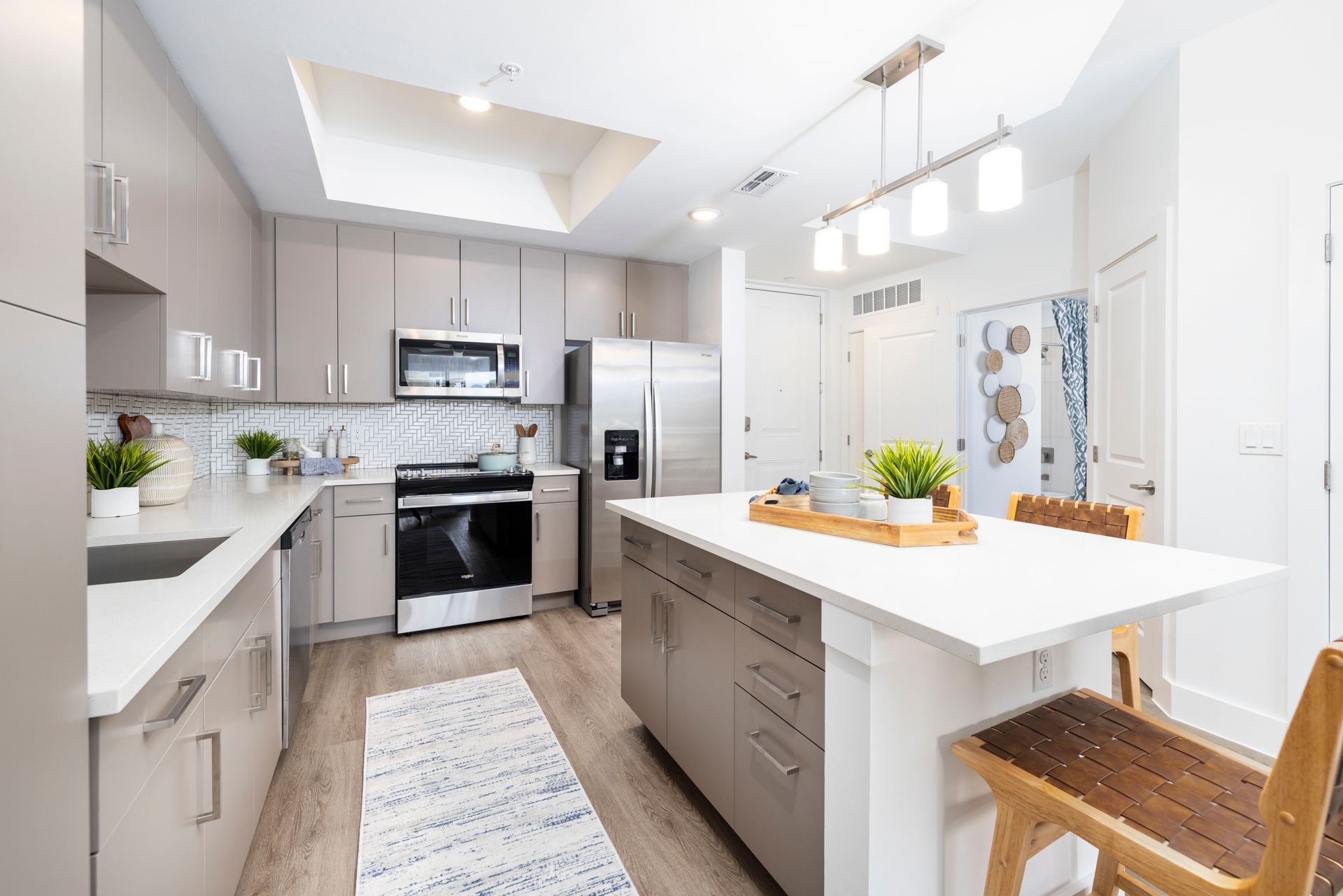 A kitchen with white cabinets , stainless steel appliances , a large island , and a dining table at Corsa at Estero Crossing.