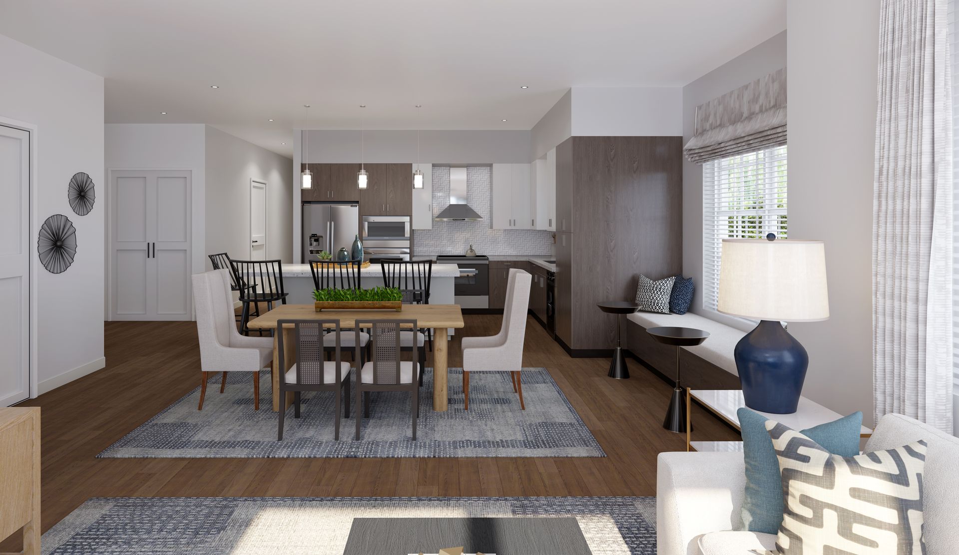 Modern open-plan living room and dining area with neutral decor, rug, and kitchen in the background