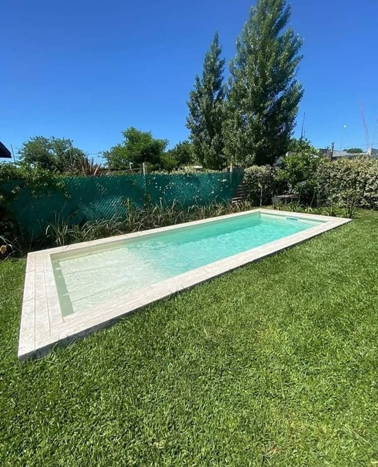 Piscina rectangular alargada en el patio trasero con agua turquesa
