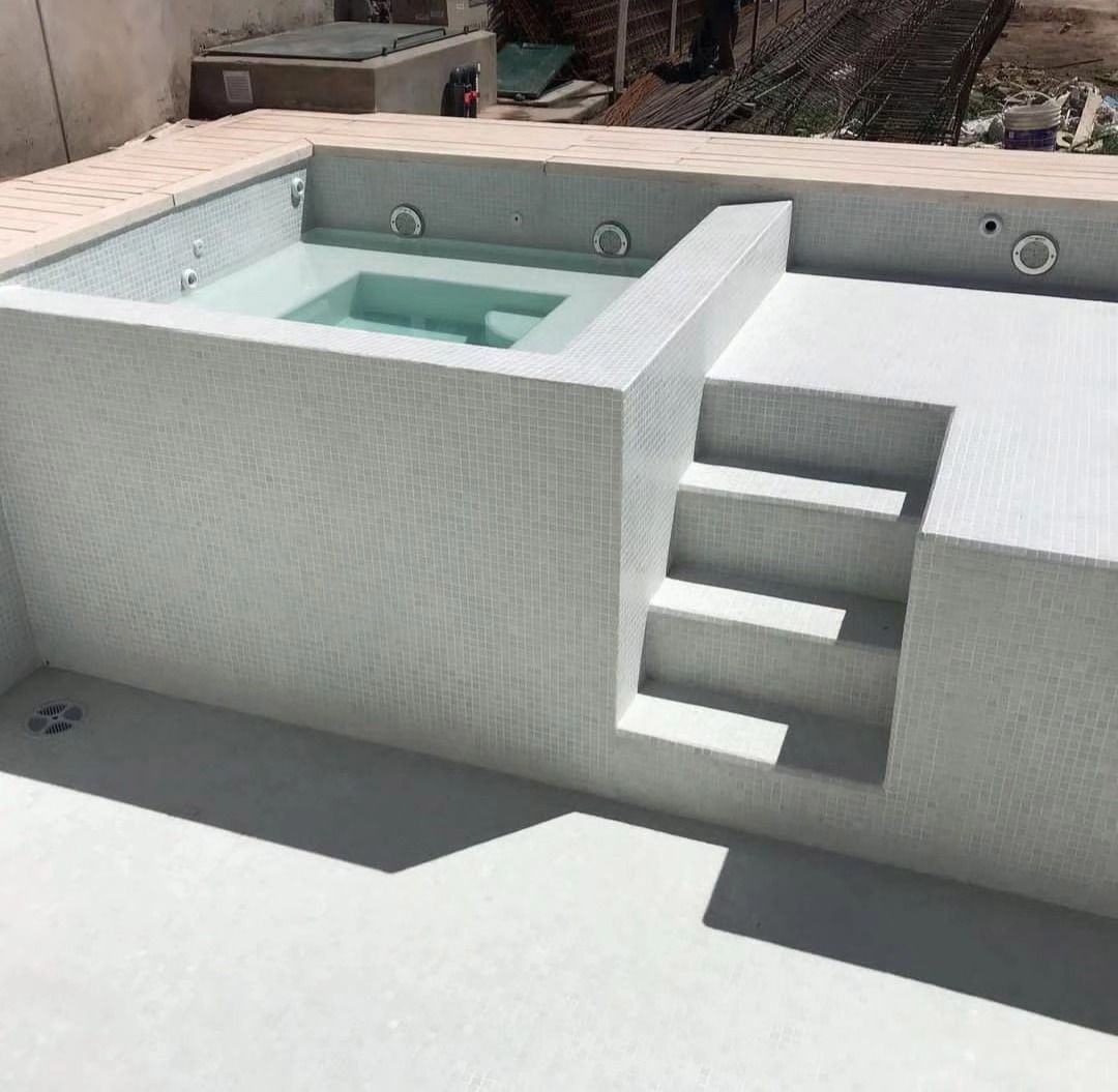 Bañera de hidromasaje exterior blanca con escalones y terraza integrados