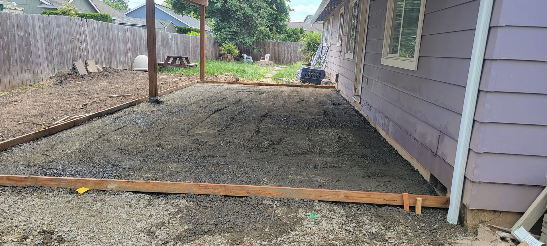 A purple house with a gravel driveway in front of it.