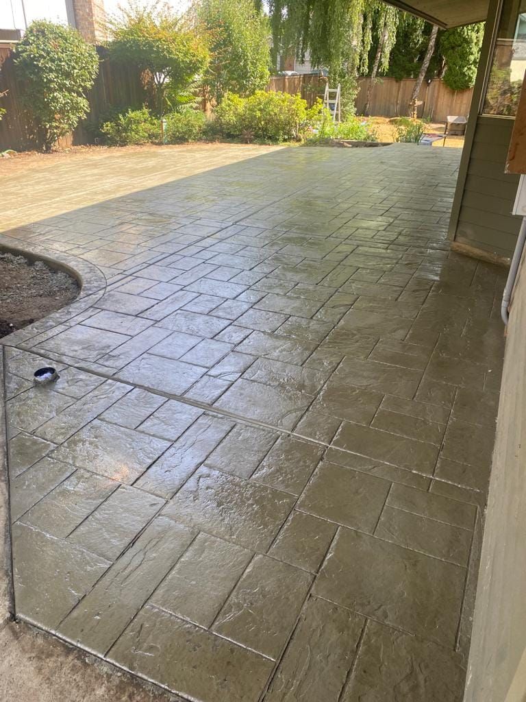 A patio with a brick pattern and a table in the middle of it.
