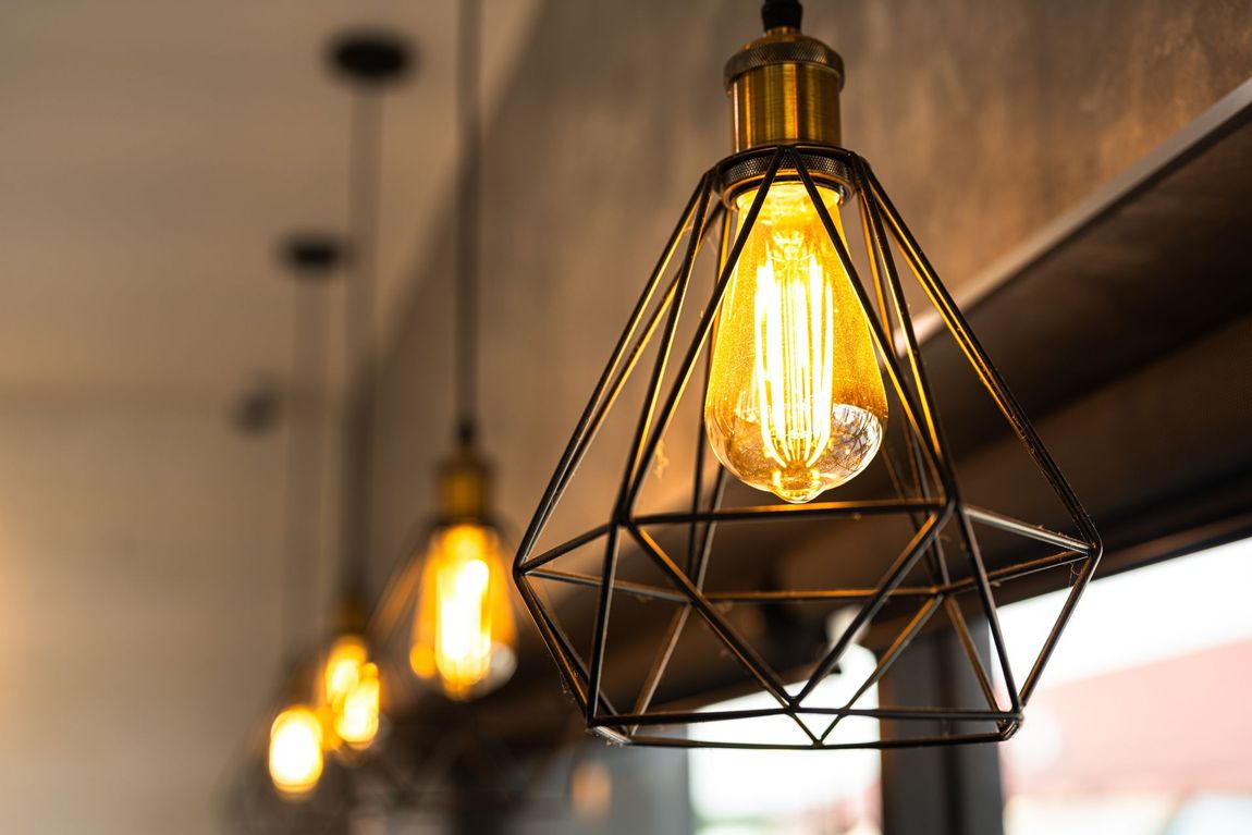 Geometric pendant lights, Edison bulbs, warm glow in modern setting.