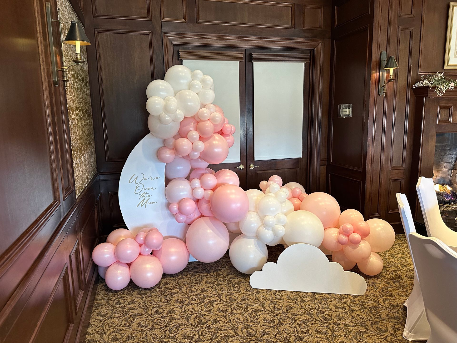 A room filled with pink and white balloons and a cloud.
