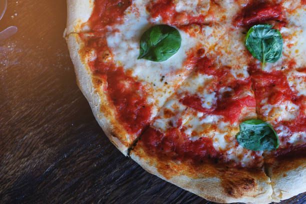 Hot Italian pizza Margarita with thick dough on a wooden table in the cafe | Chicago, IL 