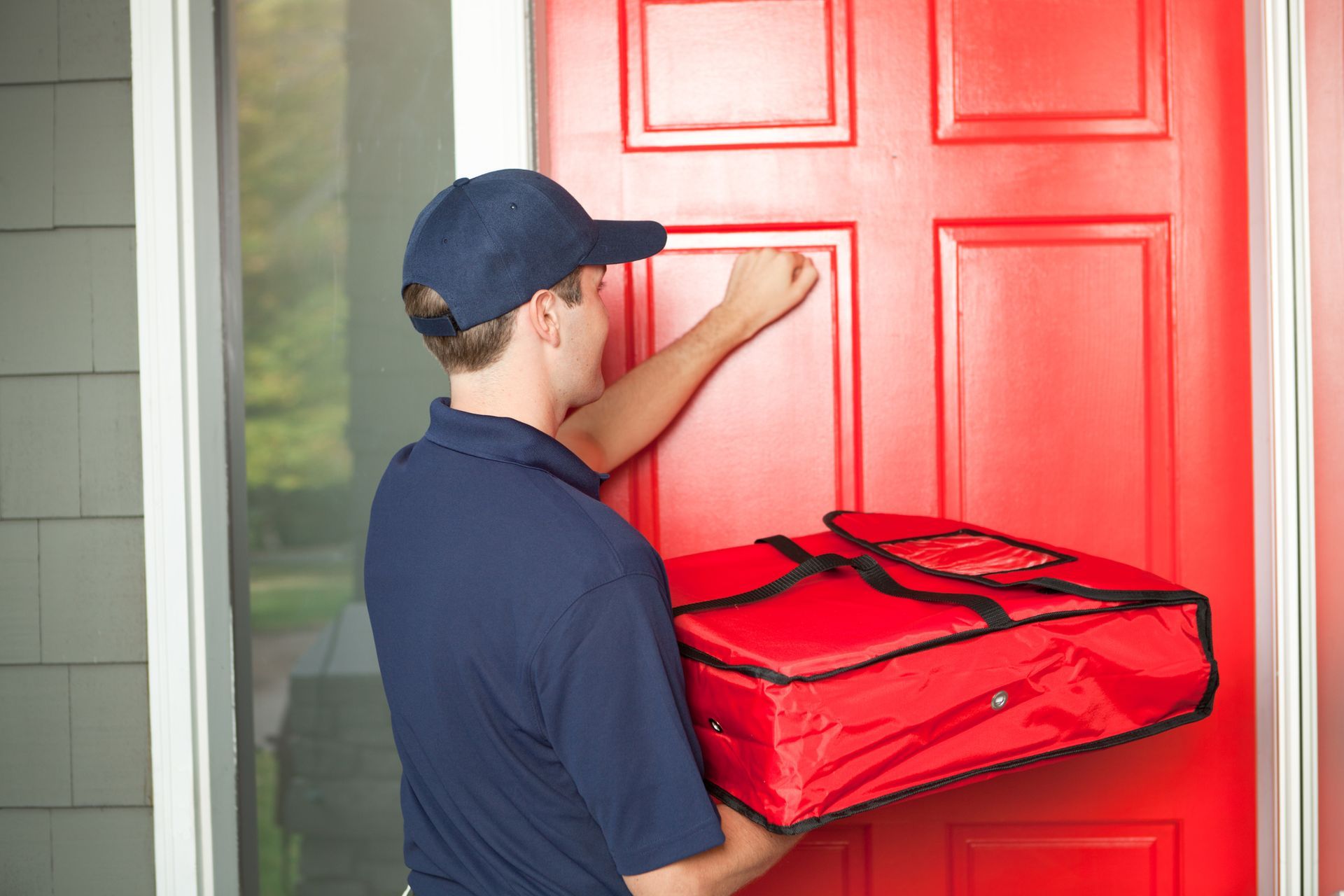 Pizza delivery man delivering food package to customer's door. Pizza delivery man delivering food package to customer's door.