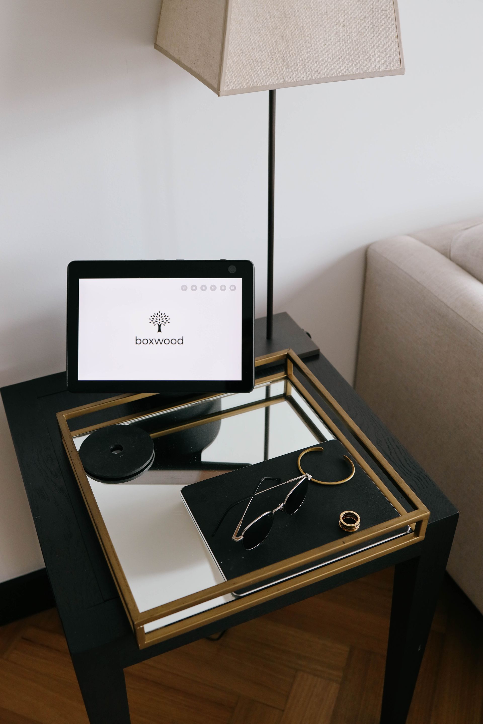 A tablet is sitting on top of a mirrored tray on a table.