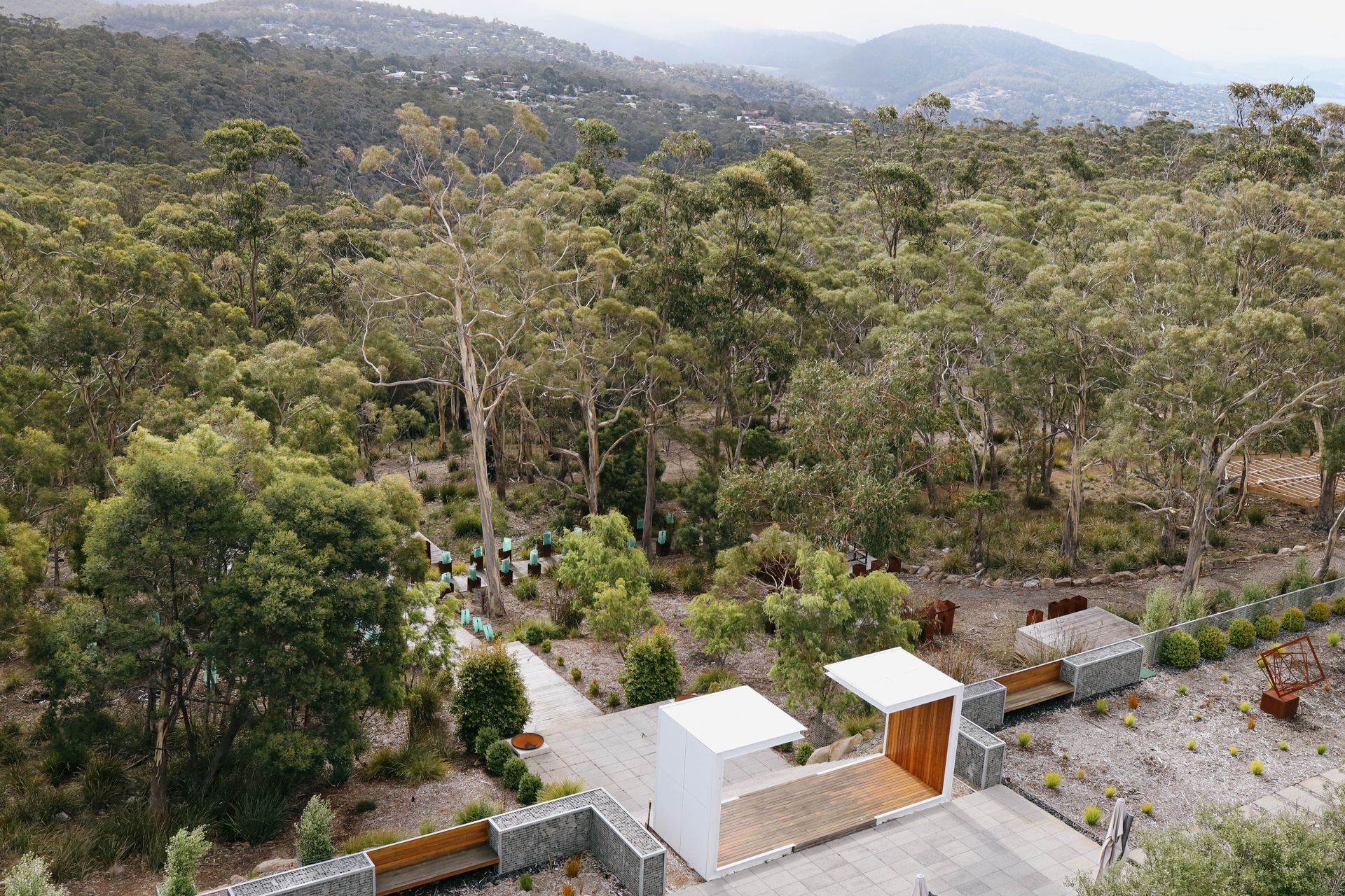 An aerial view of a house in the middle of a forest.