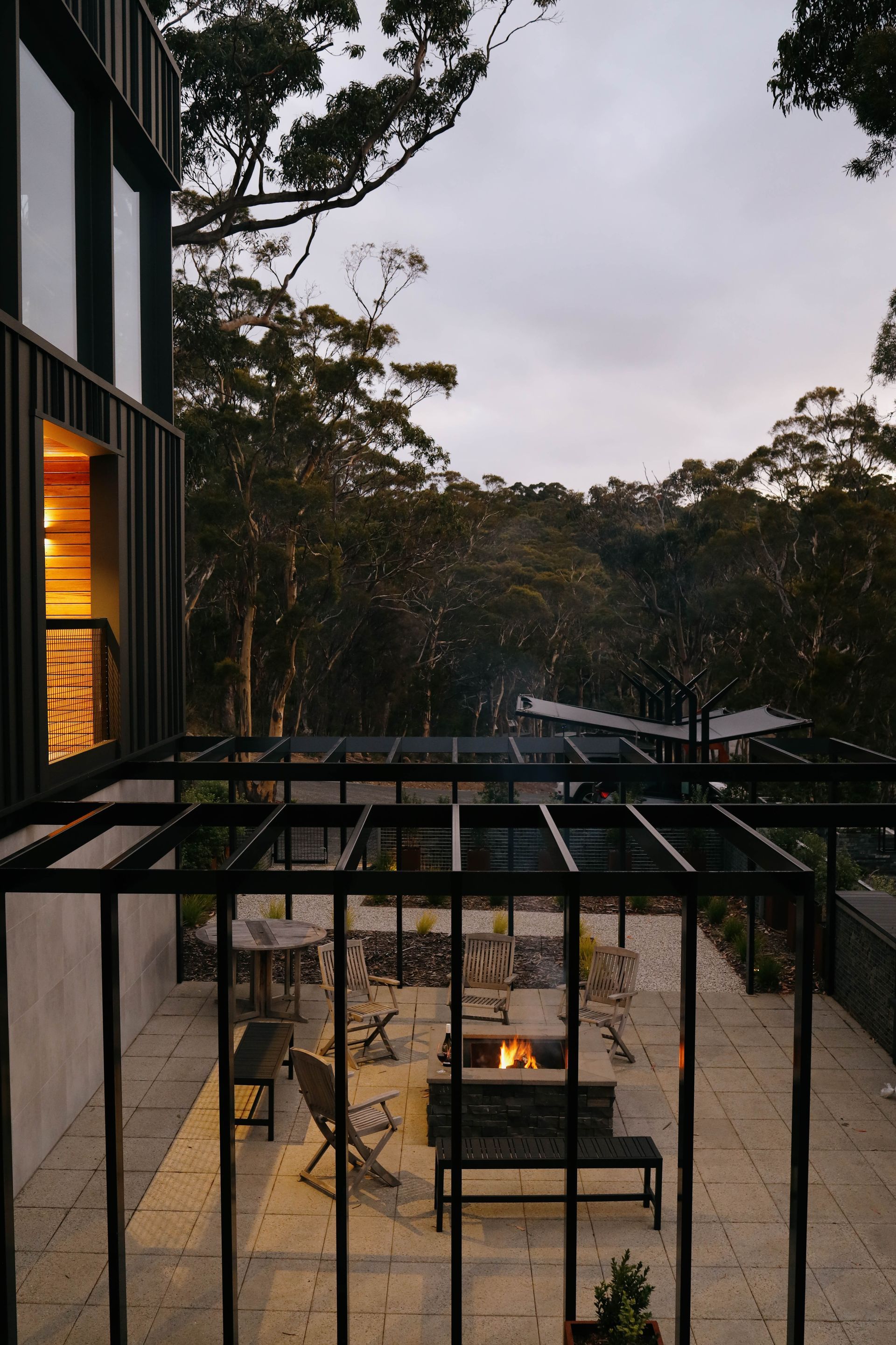 A patio with a fire pit and trees in the background