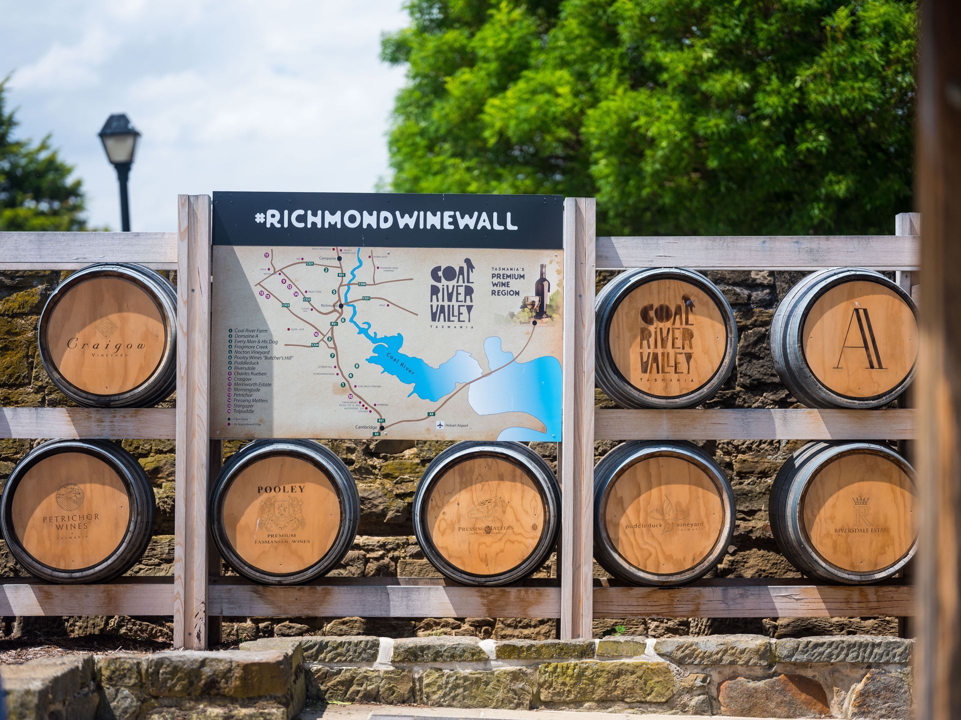A wooden fence with barrels and a sign that says richmond winewall.