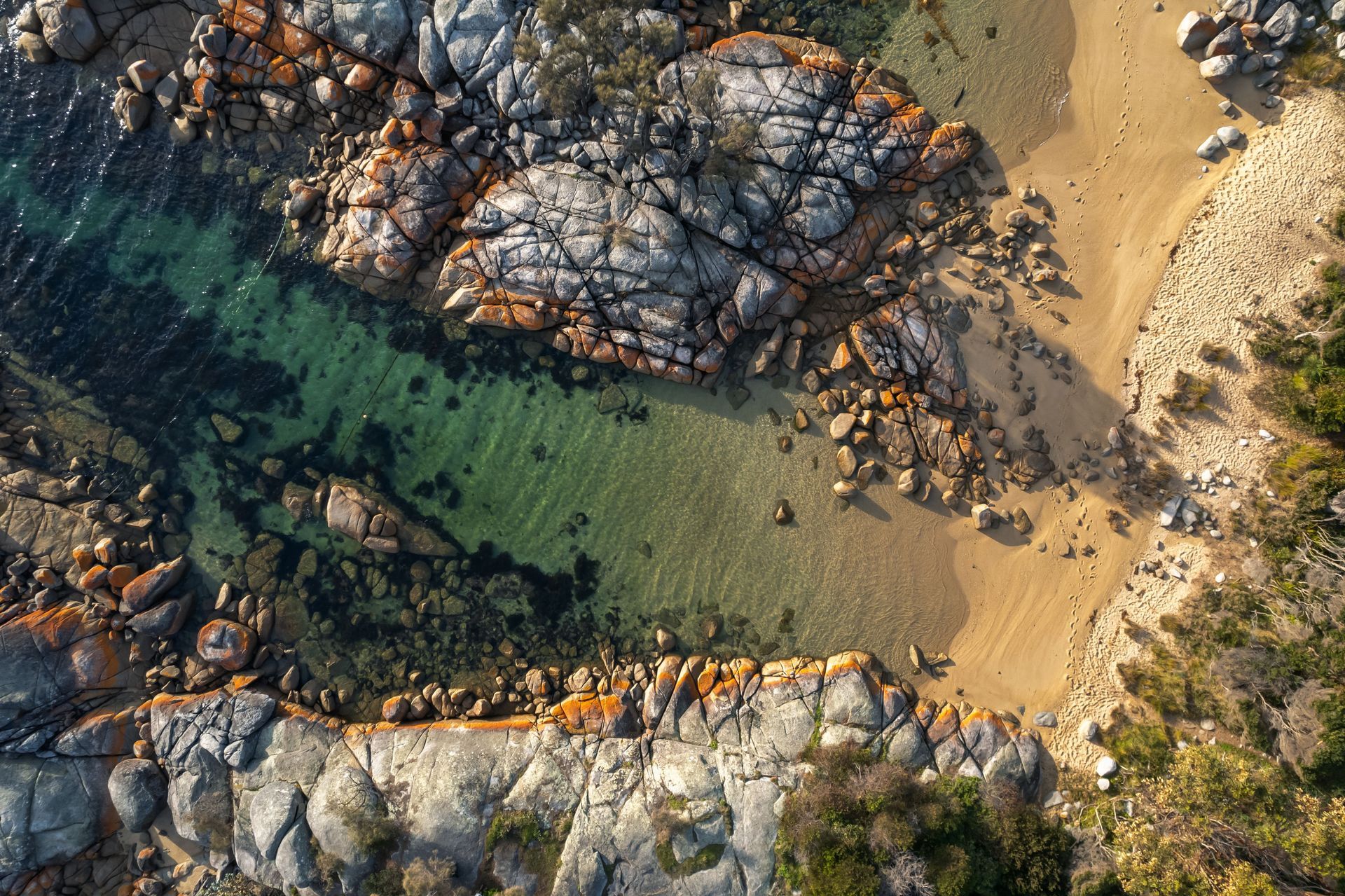 An aerial view of a rocky shoreline next to a body of water.