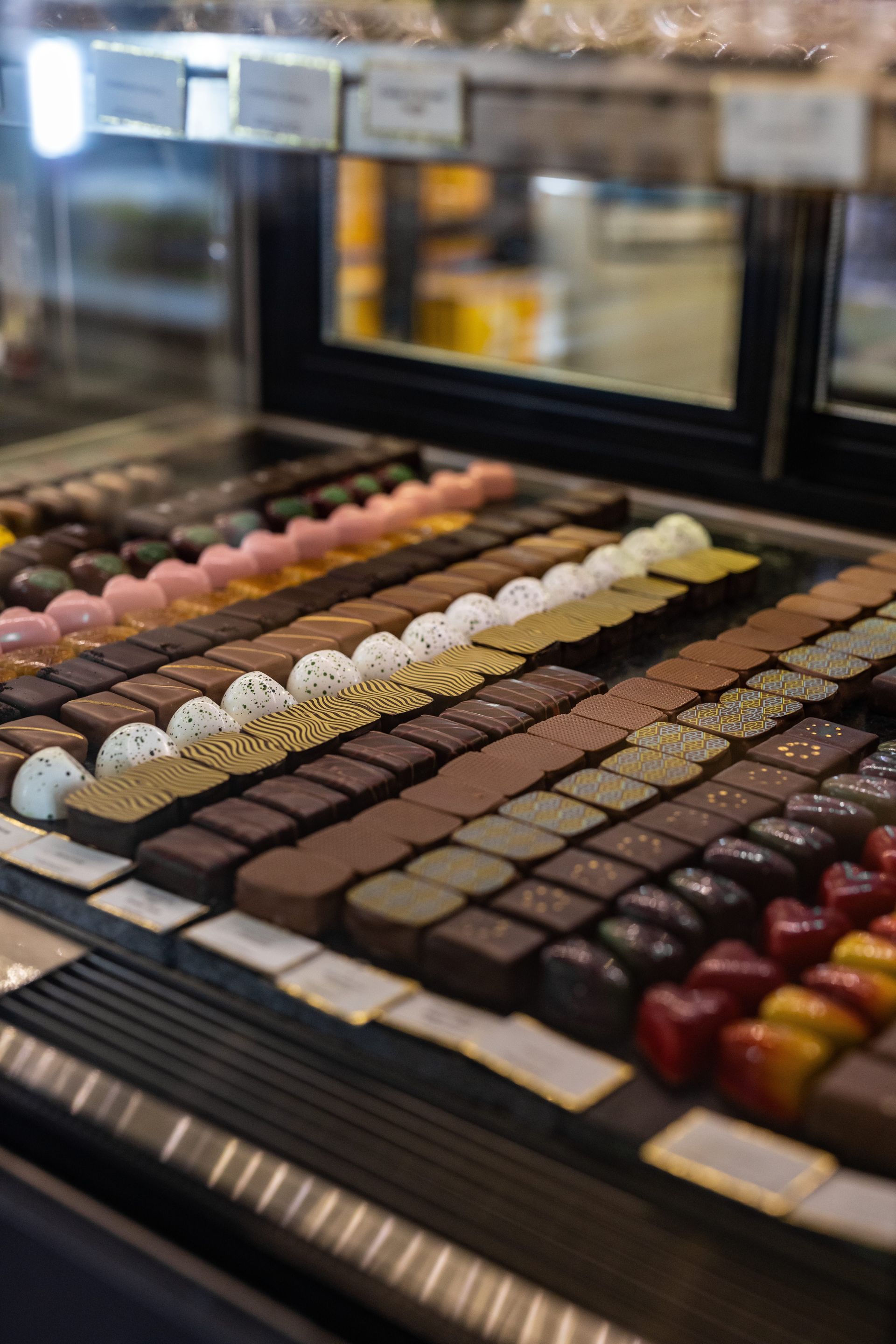 A display case filled with lots of different types of chocolates.