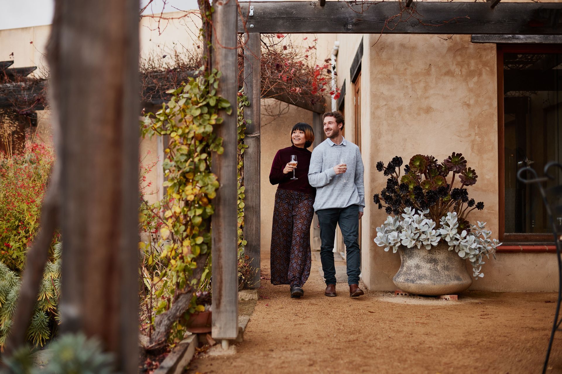 A man and a woman are standing in front of a house.